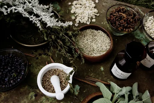 Spices, herbs and mortar and pestle on a dark table