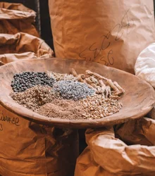 Sacks of spices with a bowl of dried botanicals
