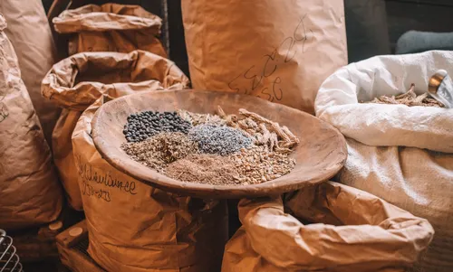 Sacks of spices with a bowl of dried botanicals