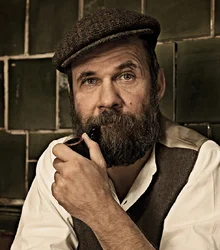 Portrait of Christoph Keller with pipe and flat cap