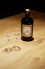 Monkey 47 bottle with two glasses on a wooden table