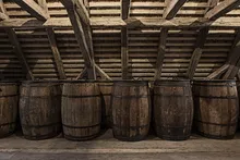 Oak barrels under the wooden beams of the old granary