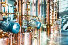 Close-up of the copper still apparatus with pipes and motor