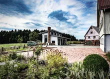 Zum Wilden Affen distillery with garden under blue sky