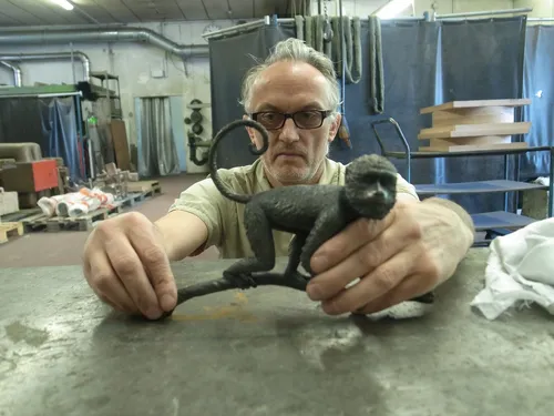 Craftsman holding the finished Species Rara Award monkey sculpture