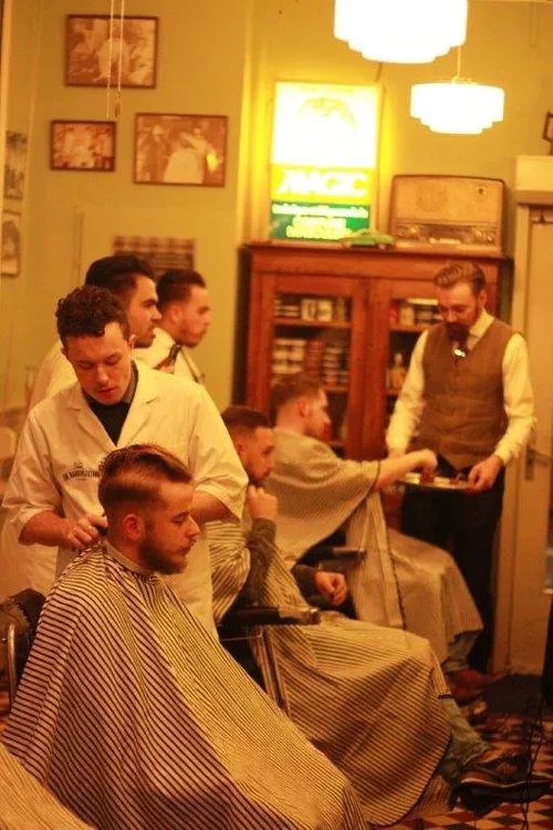 Barbers giving guests a shave in a traditional barbershop