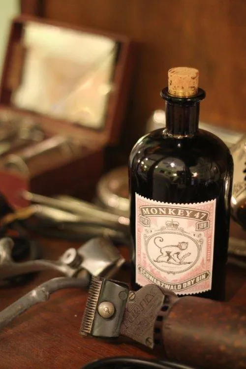 Monkey 47 bottle next to barber tools and a shaving brush