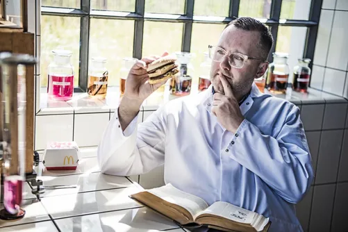 Man in lab coat tasting a pickled onion