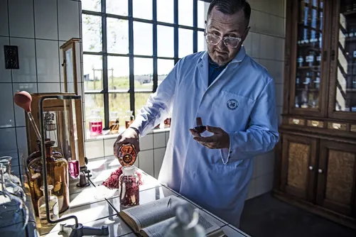 Man in lab coat pouring liquid in the laboratory
