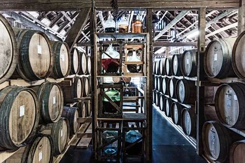 Rows of wooden barrels on racks in a cellar