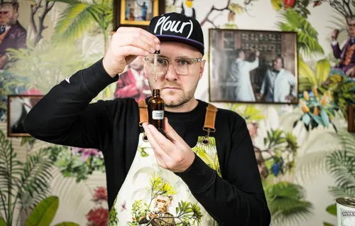 Bartender examining a bottle of infusion