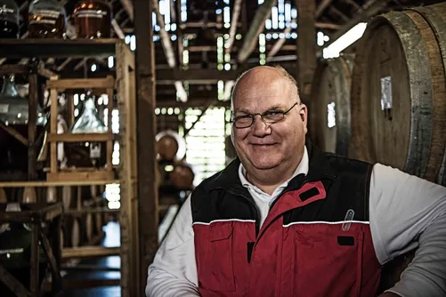 Smiling man in a barrel cellar