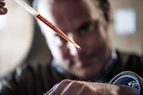 Man examining a sample with a pipette