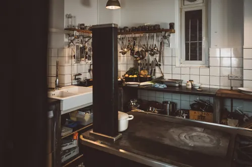 Restaurant kitchen with a stove and hanging utensils