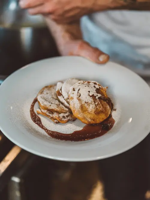 Plate of apple fritters dusted with sugar