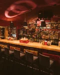 Curved bar counter with backlit shelves at Boutiq'Bar