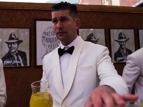 Bartender in a white dinner jacket at Door 74
