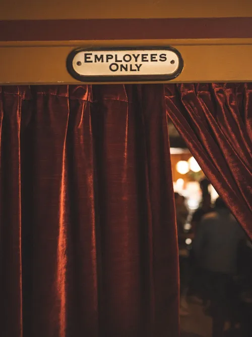 Employees Only sign above a red velvet curtain