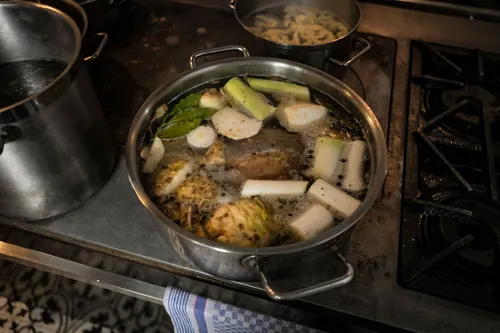 Pot of beef broth with vegetables on the stove