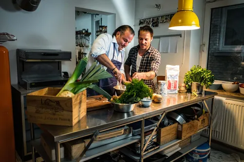 Two chefs cooking together in a kitchen