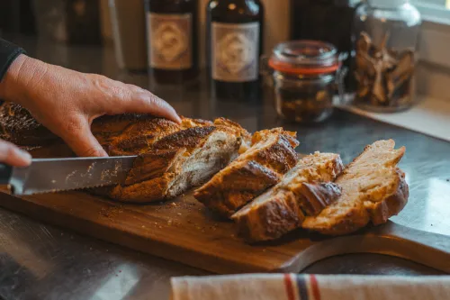 Slicing a freshly baked hazelnut braid on a wooden board