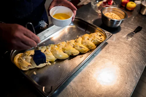 Brushing egg wash onto a braided yeast plait