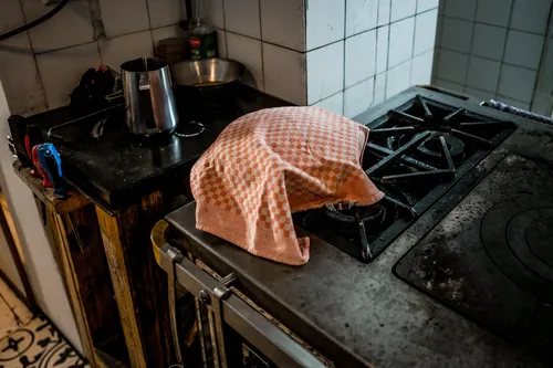 Dough resting under a checked tea towel on a vintage stove