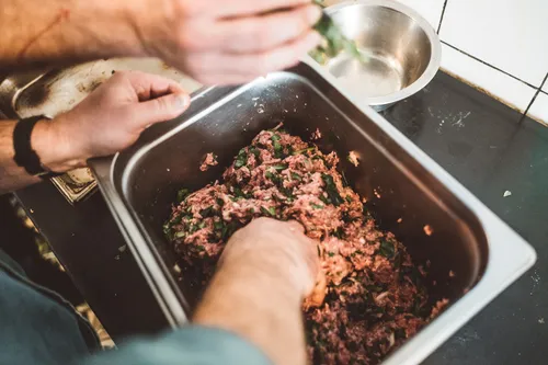 Mixing minced meat filling in a steel tray