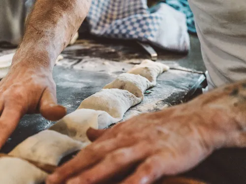 Hands shaping Swabian Maultaschen on a floured counter