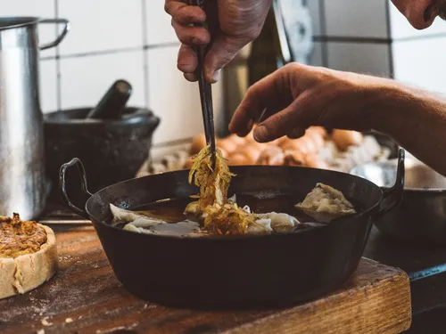 Topping Maultaschen in a pan with fried onions