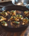 Pan of Maultaschen garnished with onions and herbs