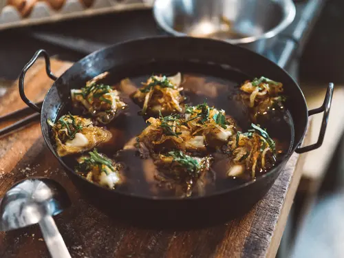 Pan of Maultaschen garnished with onions and herbs
