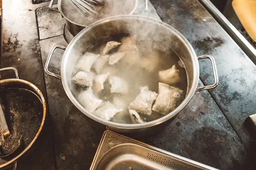 Maultaschen cooking in a large pot of water