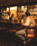 Guests sitting at the warmly lit Monkey Bar counter