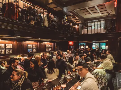 Crowded wood-panelled bar at NoMad New York
