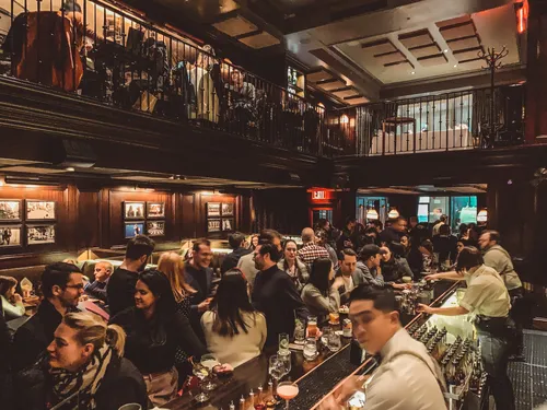 Crowded wood-panelled bar at NoMad New York