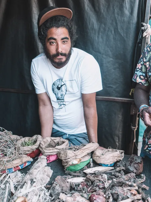 Man sitting behind sacks of dried botanicals