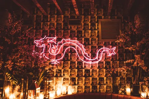 Pink neon dragon on a wall at Peachy's