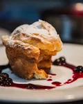 Dessert soufflé with berry sauce on a white plate