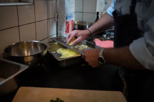 Chef preparing potato salad in a steel tray