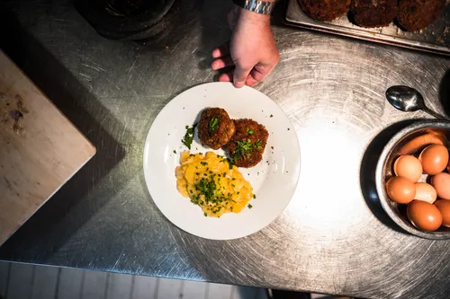 Meat patties with potato salad on a white plate
