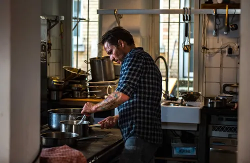 Chef working at the stove by a kitchen window