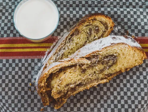 Slices of nut-filled yeast loaf with a glass of milk