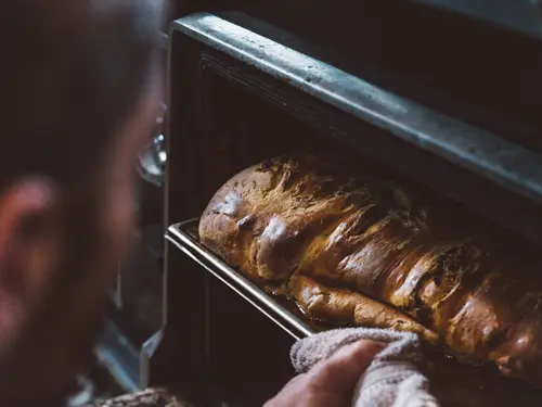 Taking a braided nut loaf out of the oven