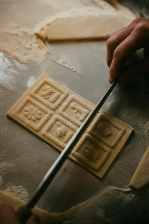 Pressing a carved mould into Springerle dough