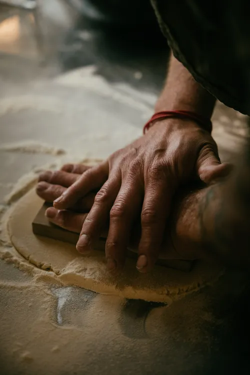 Hands pressing Springerle dough flat