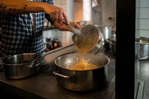 Pouring sauce into a pan on the stove