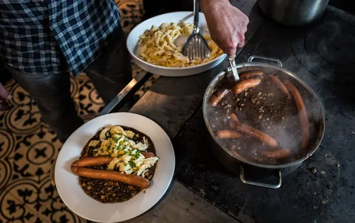 Serving lentils, sausages and Spätzle from the pot