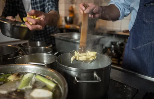 Lifting fresh Spätzle out of a steaming pot