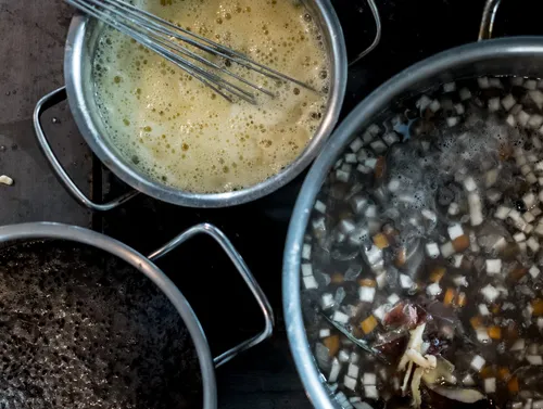 Pots of Spätzle dough and simmering broth on the stove